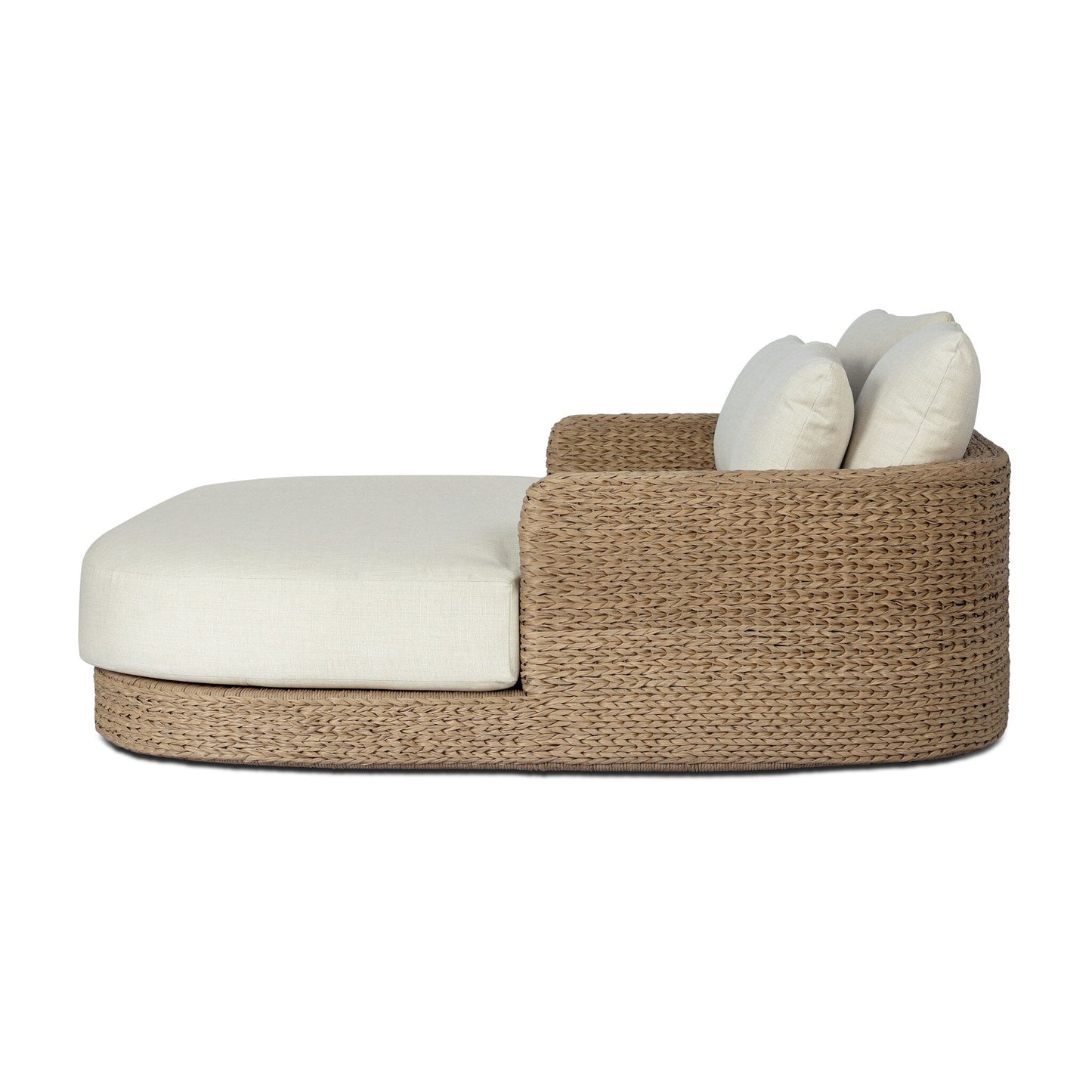 The Chaney Outdoor Double Chaise, shown from the side on a white background, features woven rattan, a beige cushion, two matching pillows, a curved low back and armrest. Dimensions: 62.00"w x 71.25"d x 32.75"h.