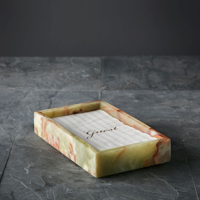 A Green Onyx Guest Towel Tray holds a folded white guest towel embroidered with "Guest," set on a gray stone countertop.