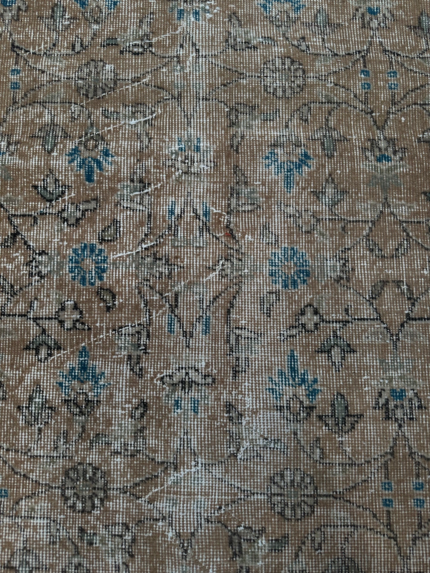 A close-up of the Vintage Beige and Blue Runner 2x6 showcases its faded floral pattern in blue and beige, with visible wear and distressed texture that highlight the rug’s vintage charm.
