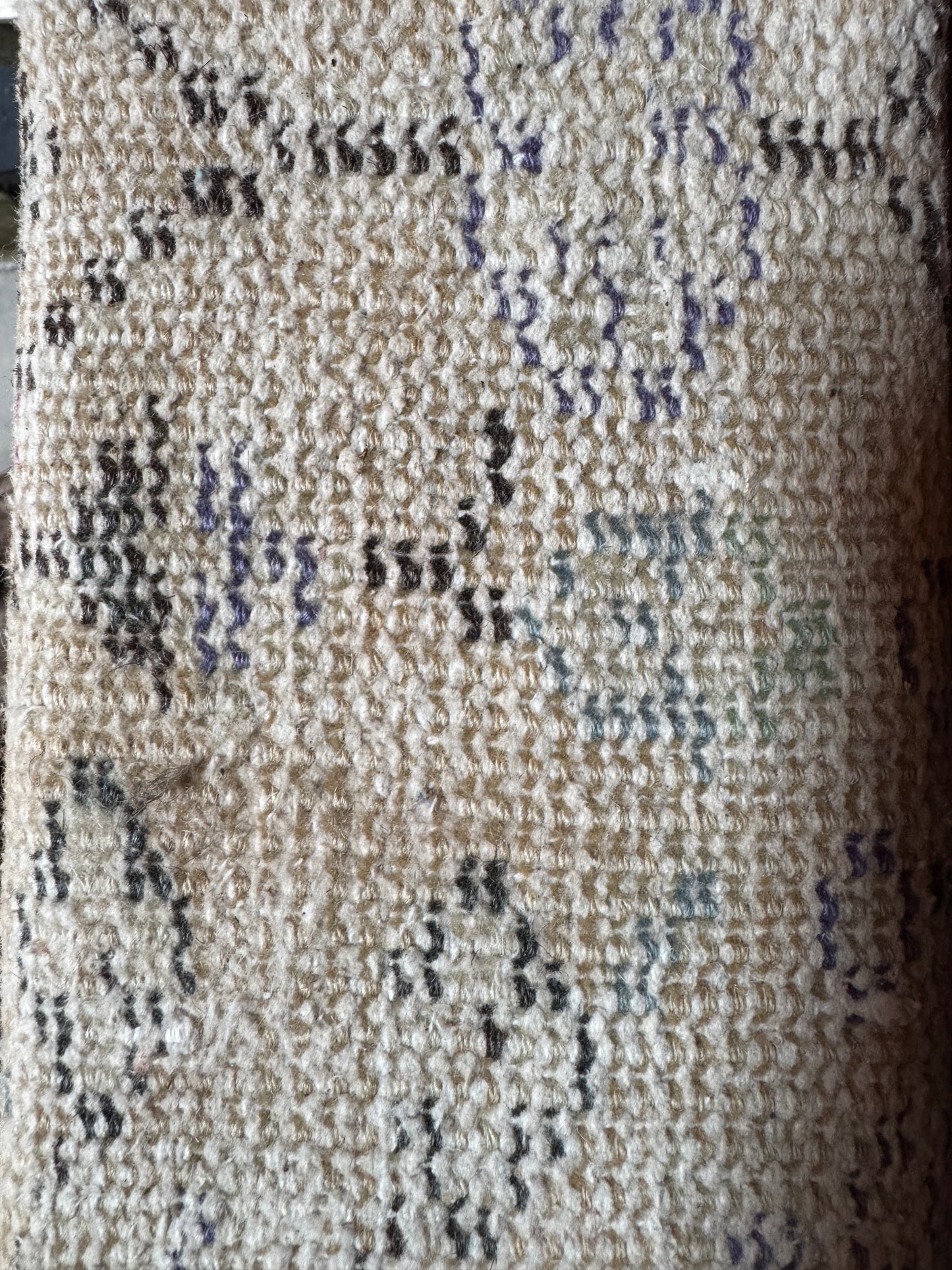 Close-up of the Vintage Turkish Runner Rug, showcasing textured beige fabric with a woven pattern and scattered abstract shapes in black, gray, green, and purple. The soft surface evokes a cozy, vintage feel.