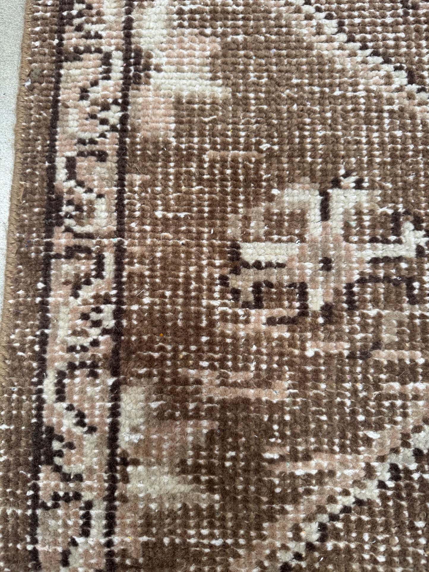 Close-up of a Vintage Turkish Runner Rug, 3' x 5', featuring a brown pattern with a decorative border and light beige geometric and floral motifs. The texture of the rug’s fibers and weave details are clearly visible.