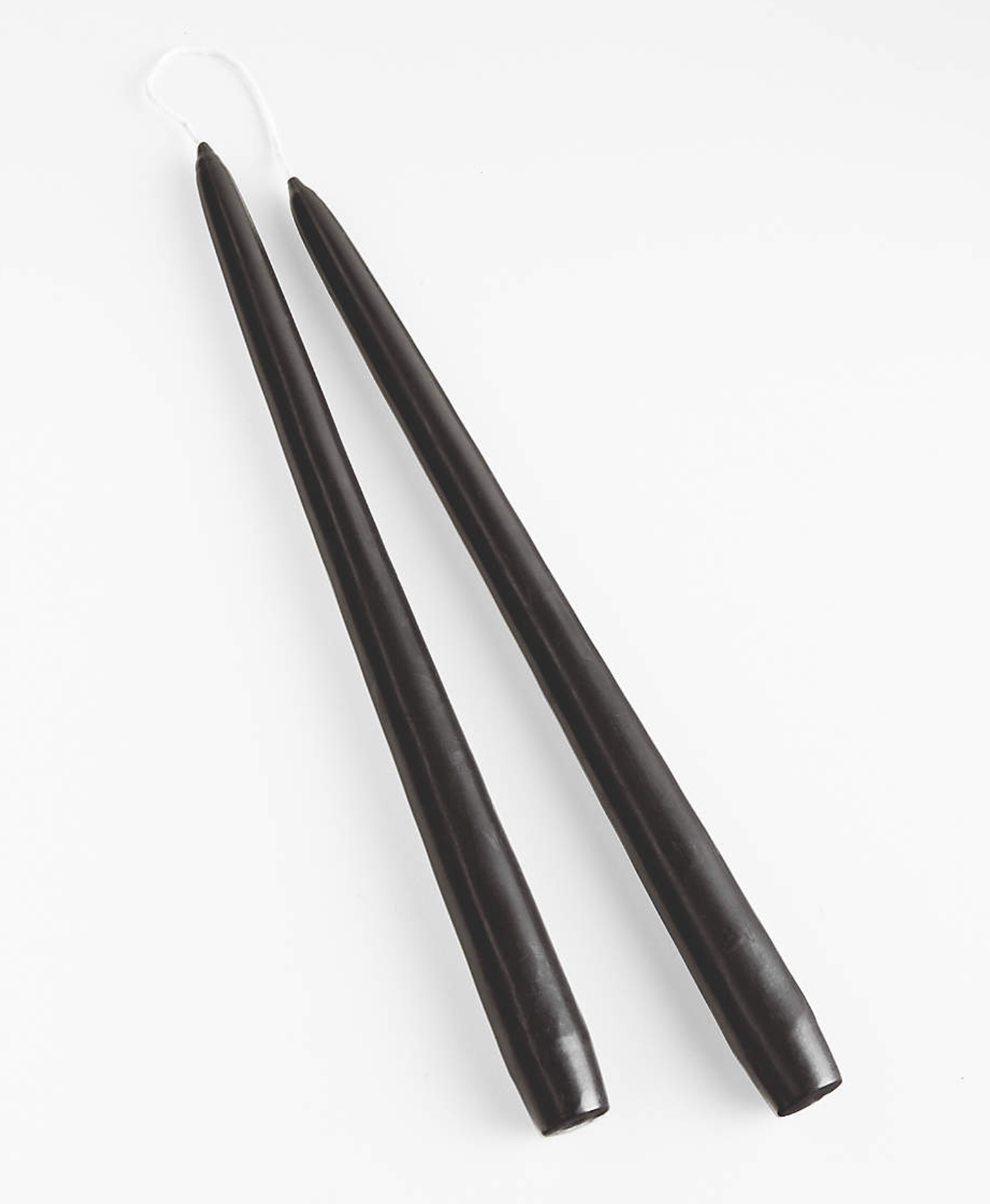 The Black Wax Taper Candle (Set of 2) features two black tapered candles placed side by side on a white background, with unlit wicks visible at the top.