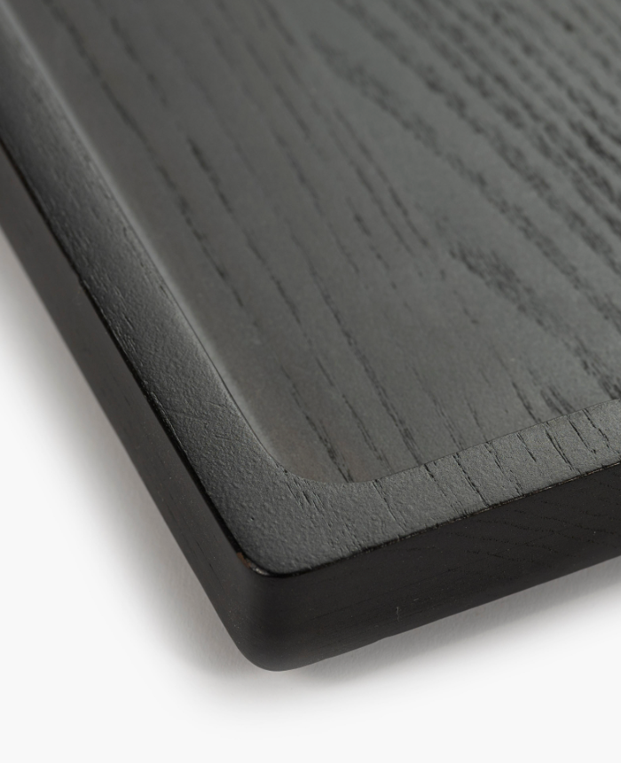 Close-up of the Small Arch Black Tray, sized 11.81"L x 7.09"W x 0.98"H, featuring a smooth, slightly raised edge and visible carbonised ash wood grain texture.