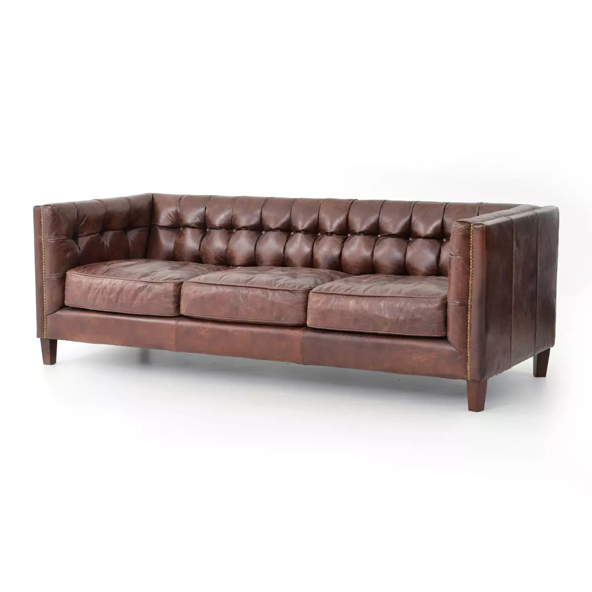The Cigar Leather Sofa features brown leather upholstery, tufted detailing, three seat cushions, square arms, and wooden legs, displayed on a white background.