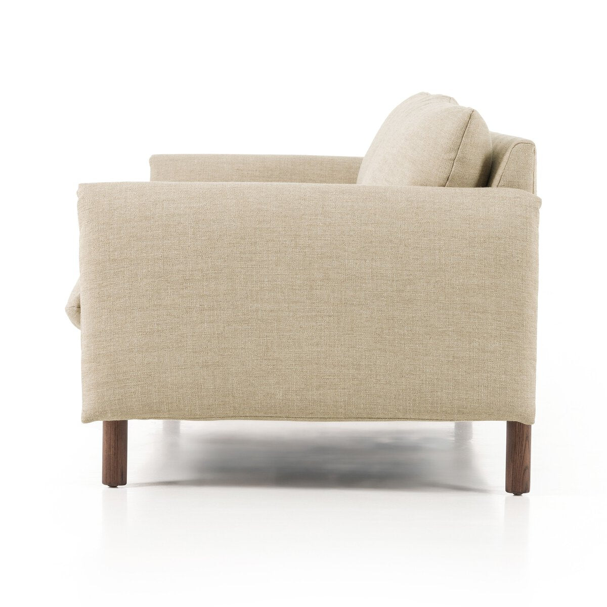 Side view of the Linen|Wood Wrap Sofa: a modern beige poly linen blend armchair with wide folded wrap arms, plush back cushion, and slim wooden legs, set against a white background.