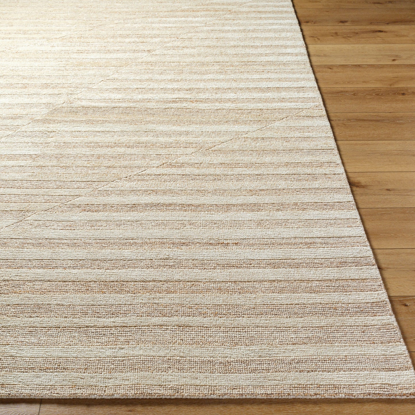 The Bone Striped Wool Rug - 8 x 10, a beige hand knotted wool rug with textured horizontal stripes, rests on a light wooden floor. Its alternating lines provide a subtle design accent to the room.