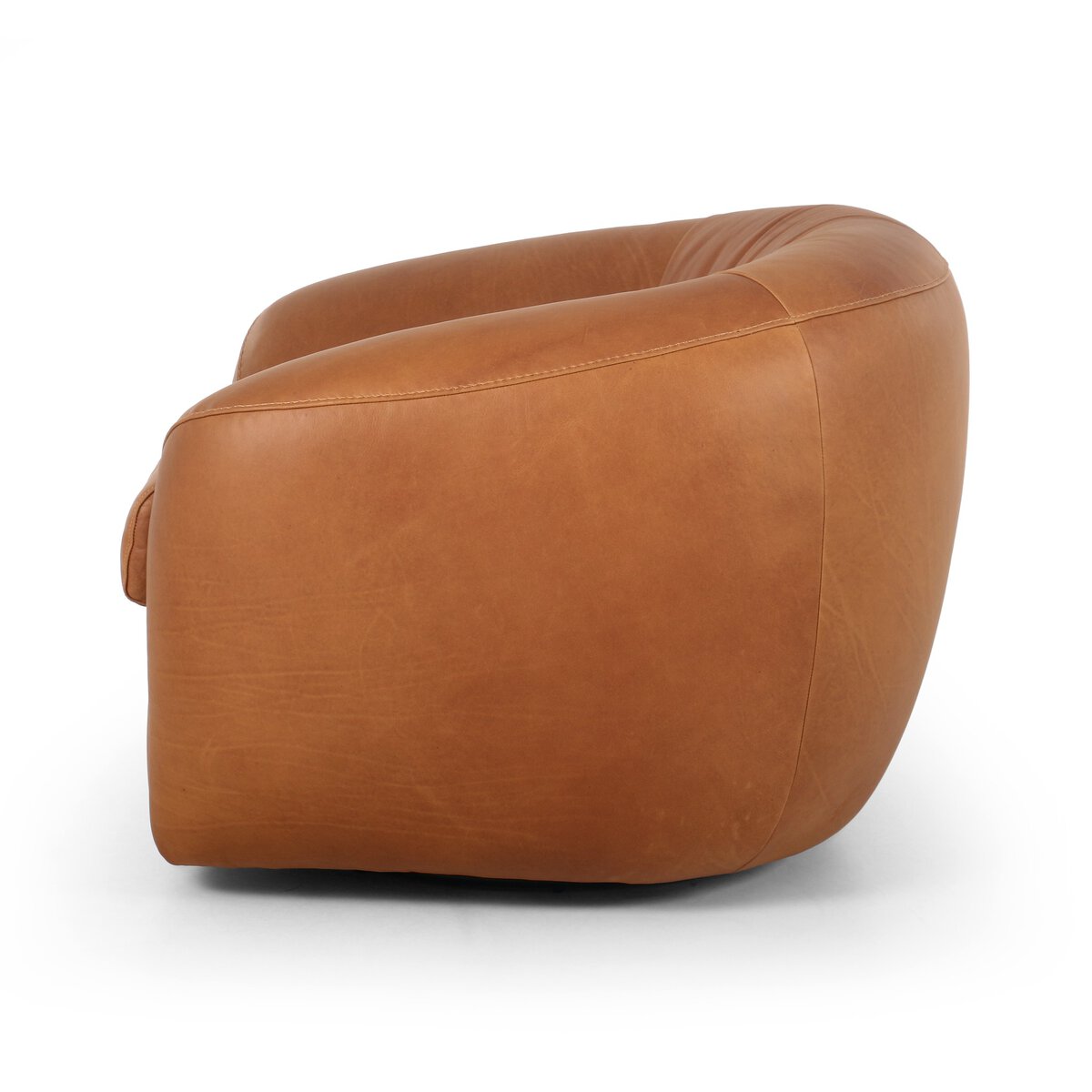 The Cognac Leather Swivel Chair features a modern, tan leather design with a rounded, low-profile silhouette and seamless upholstery, shown side view on a white background. Dimensions: 42.00"w x 36.00"d x 28.00"h.