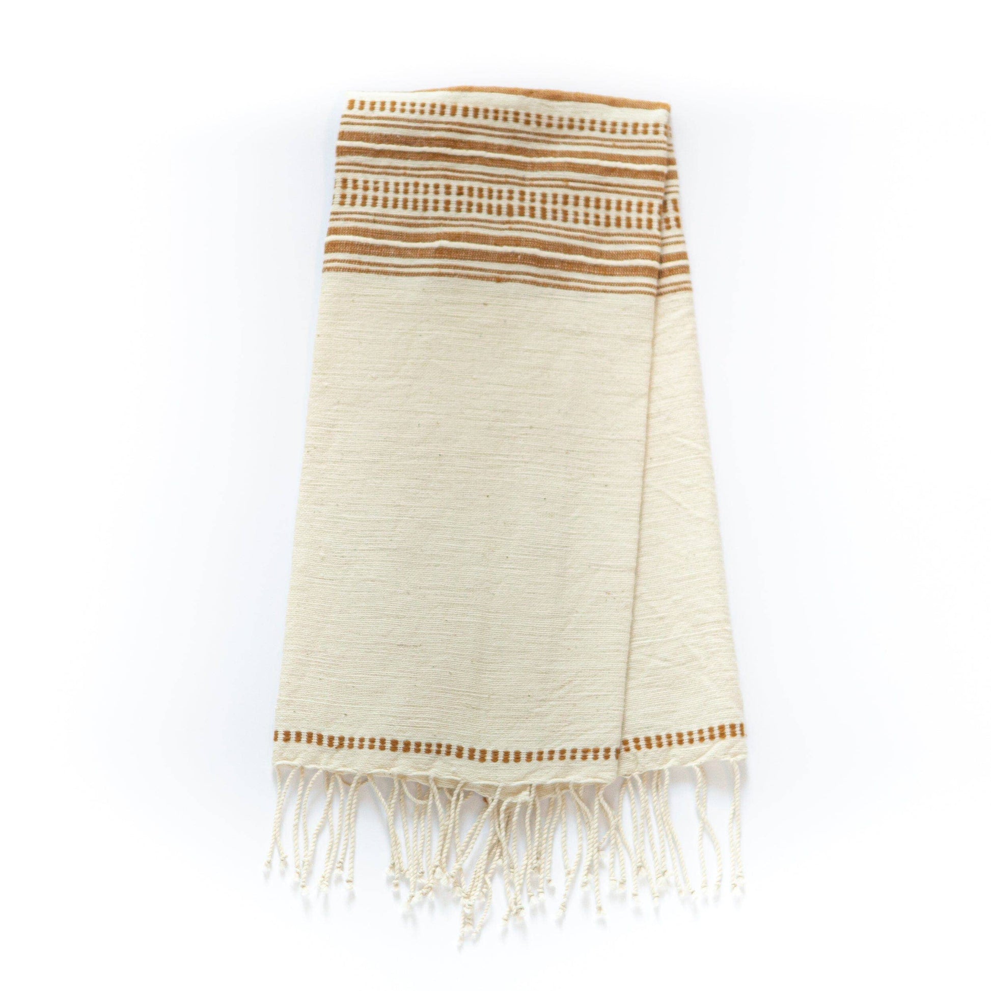 The Handwoven Ethiopian Cotton Hand Towel is cream-colored with brown horizontal stripes and decorative fringe along the bottom edge, shown folded on a white background.