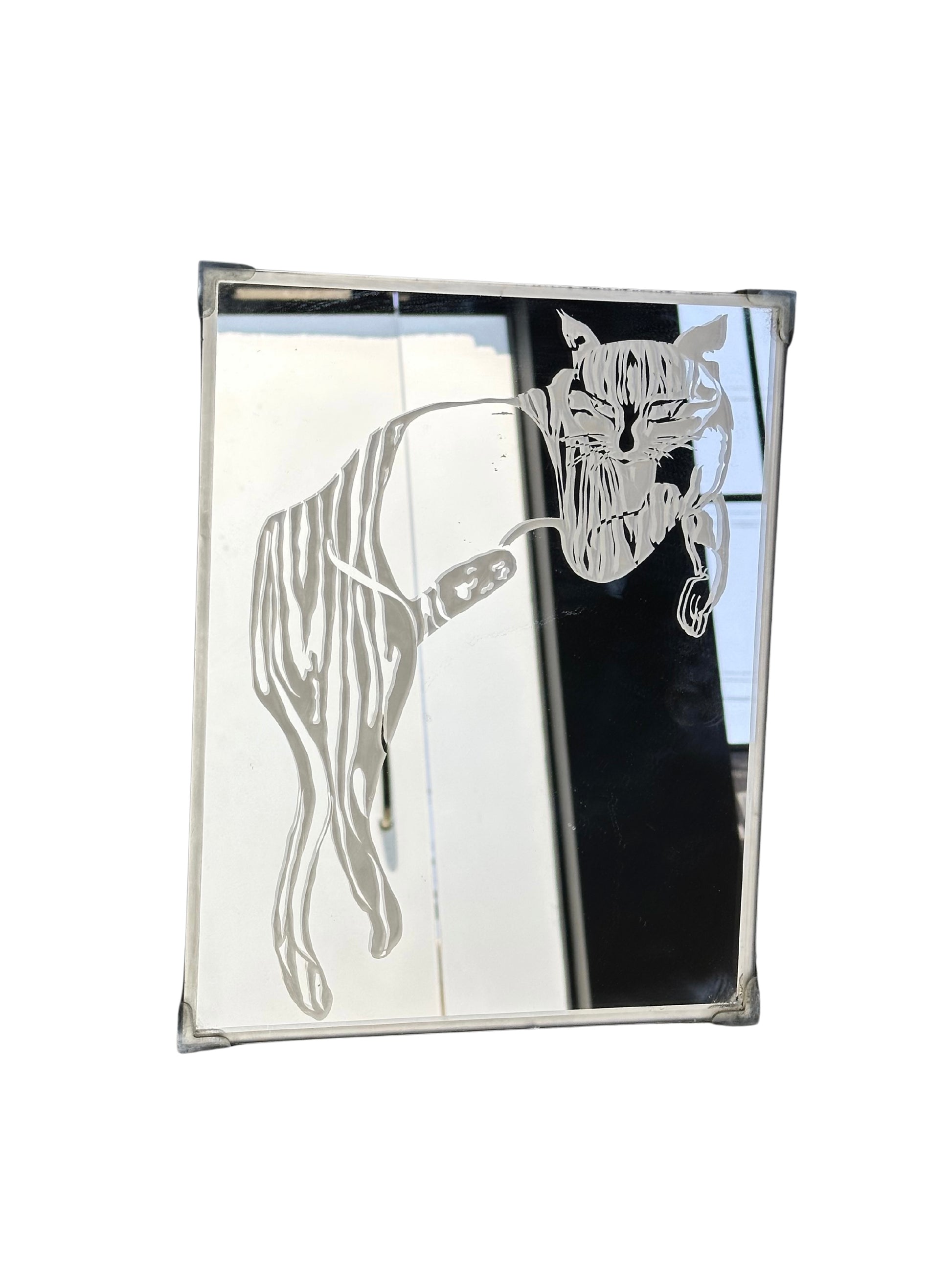 The Post Modern Mirror features an etched image of a cat lying down with its head on its paw and curled tail, set by a sunlit window, bringing contemporary style to any space.