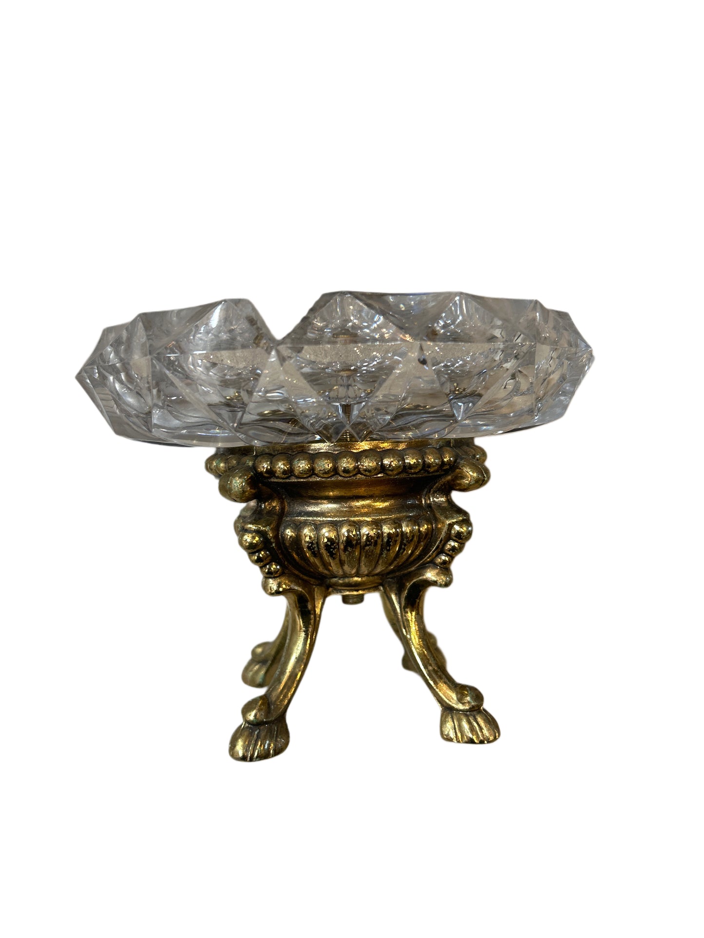 The Brass and Crystal Bowl features a faceted crystal bowl set on an ornate, gold-colored three-legged stand with paw-shaped feet and decorative accents.