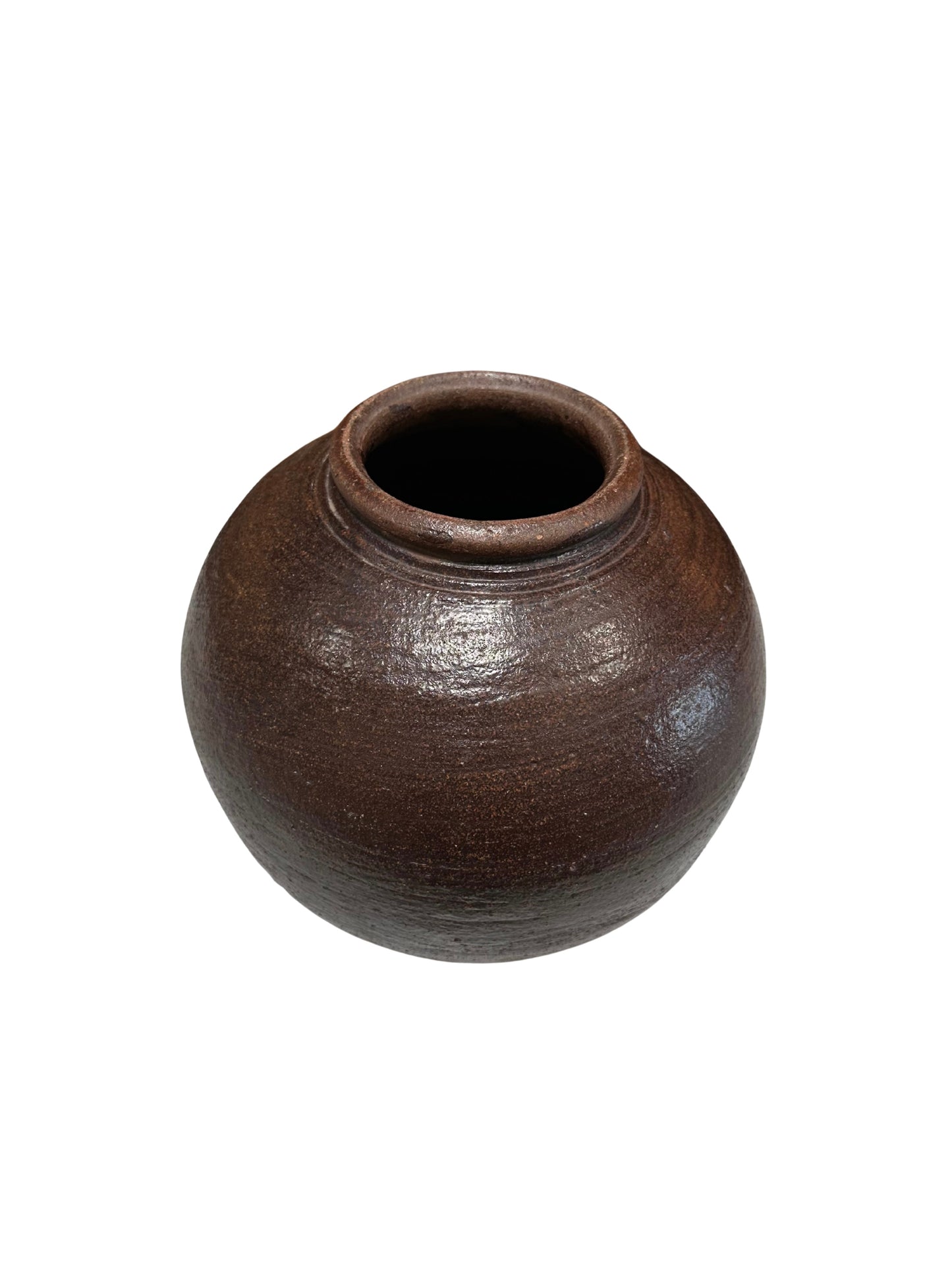 The Rustic Ceramic Vessel is a round, dark brown hand-crafted pot with a small top opening, slightly textured surface, and simple rustic design. It is shown against a white background.