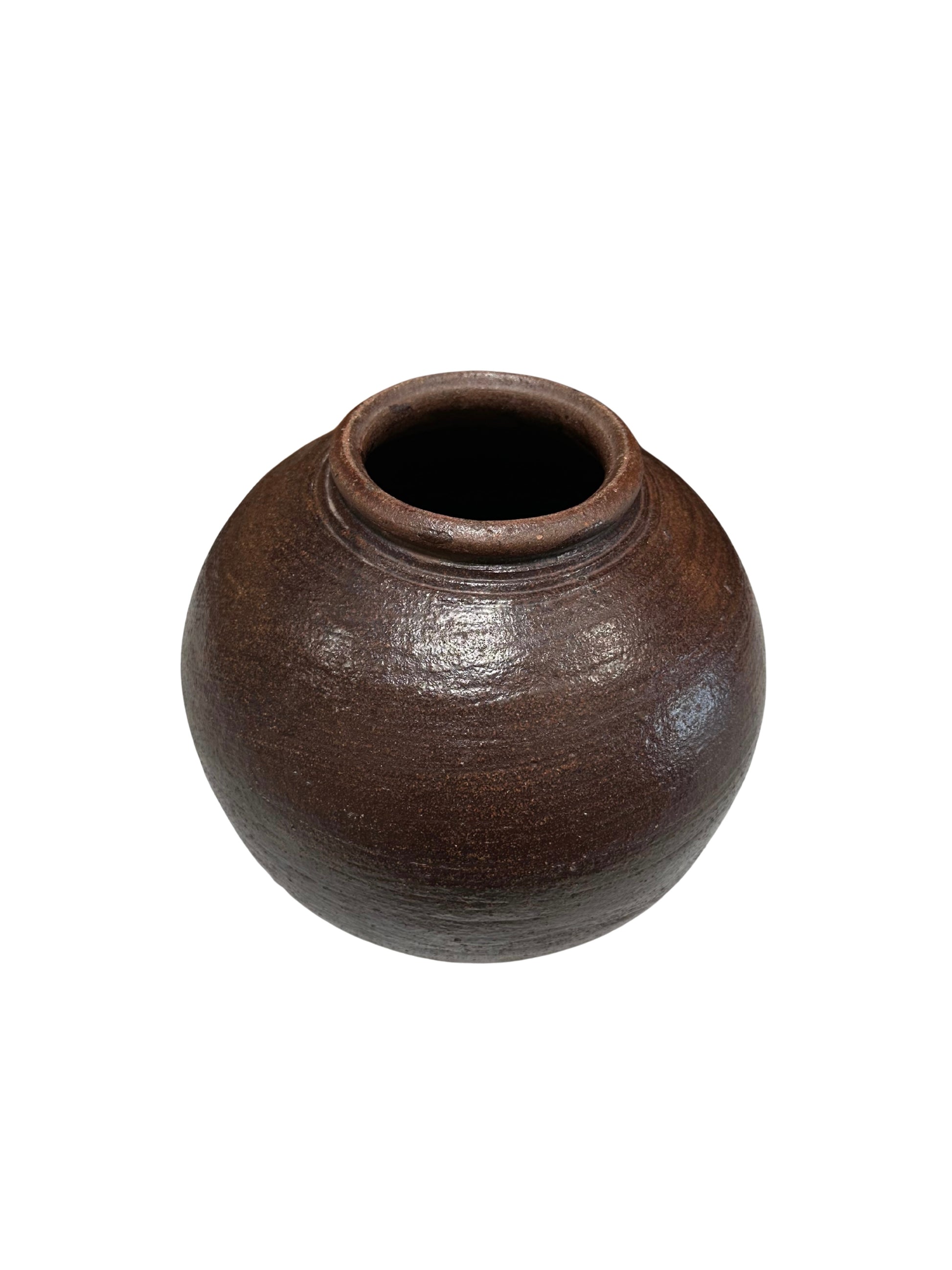 The Rustic Ceramic Vessel is a round, dark brown hand-crafted pot with a small top opening, slightly textured surface, and simple rustic design. It is shown against a white background.