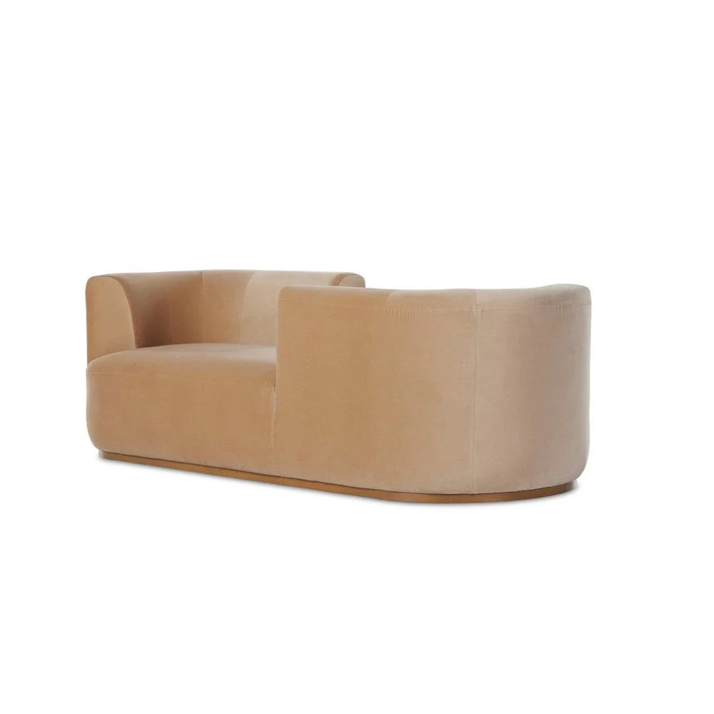 The Deandra Tete A Tete Chaise is a modern, beige velvet sofa with a curved backrest and armrests, measuring 90.50 inches. It features a low profile, smooth minimalist design, and is shown on a white background.