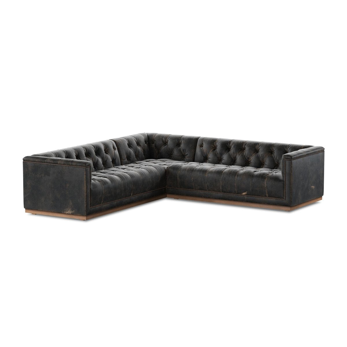 The Maxx 3-Piece Sectional features black tufted leather upholstery, deep seats, and visible stitching on the arms and cushions, all in a low-profile design for an elegant living room statement.