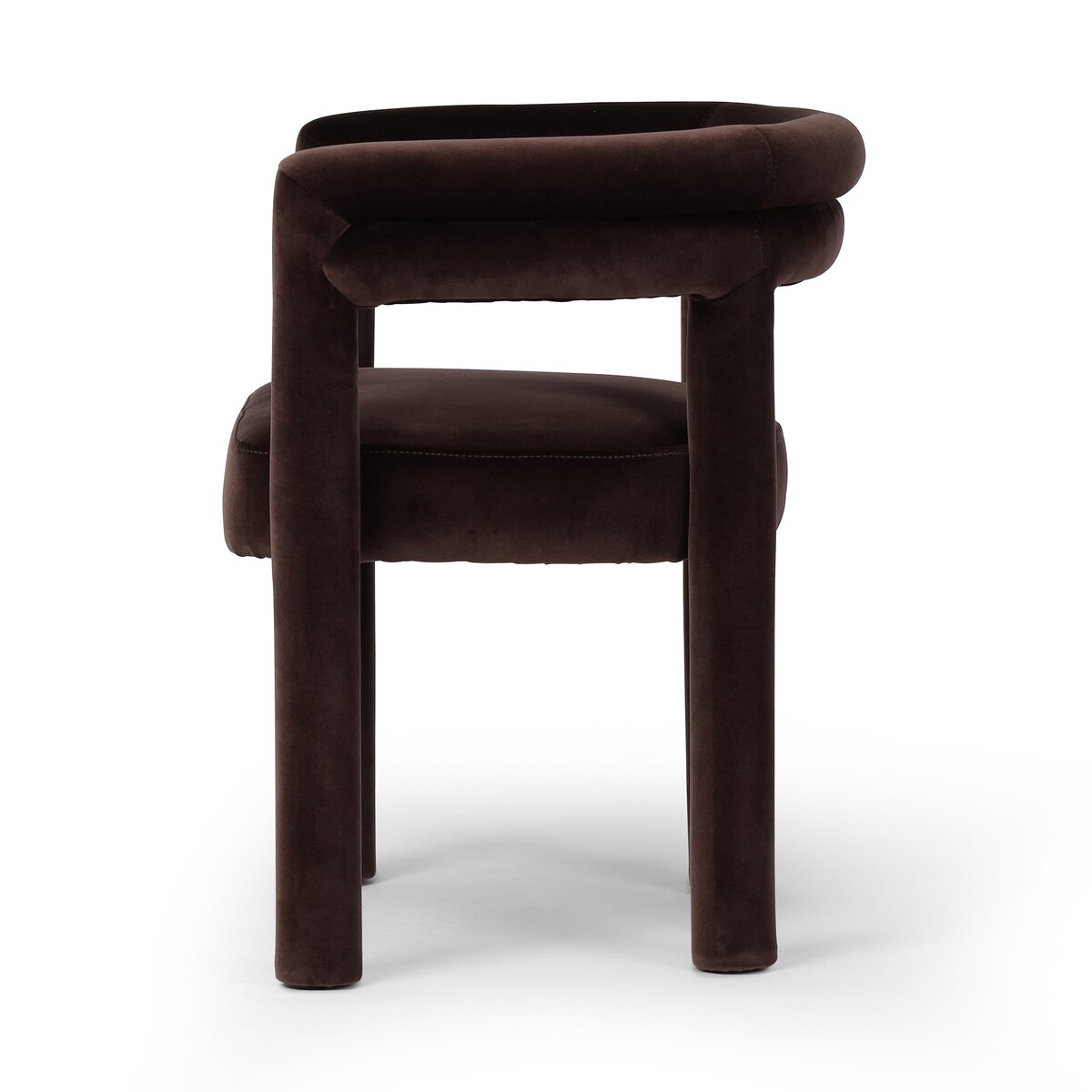 The Tacova Dining Chair is a modern, dark brown velvet ergonomic chair featuring a rounded padded backrest and cylindrical legs, shown from the side on a white background.