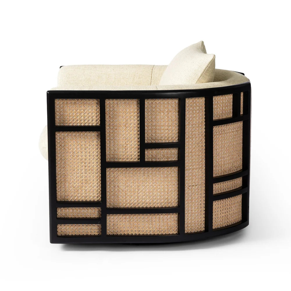June Swivel Chair featuring a curved parawood and cane frame with a geometric grid inlay and cream-colored high-performance fabric cushions.