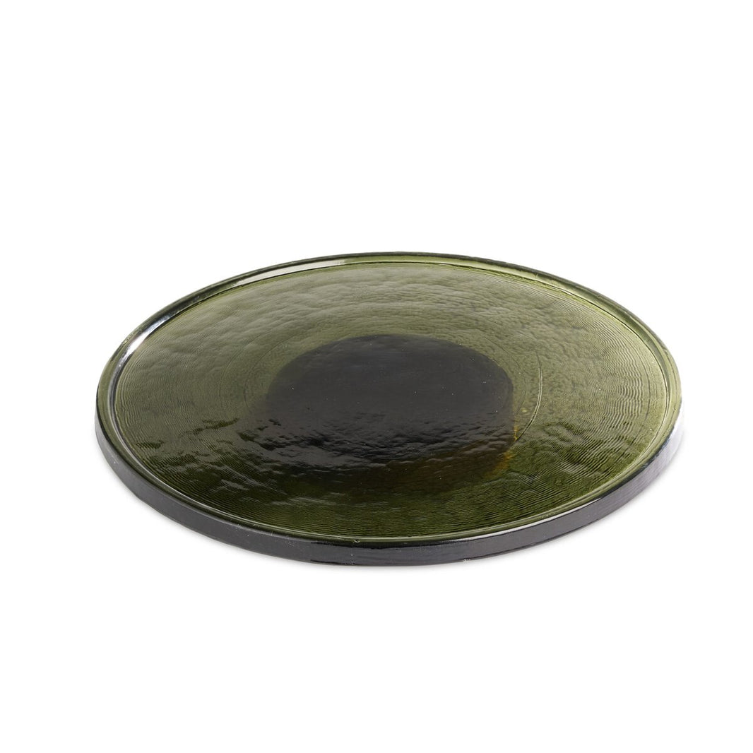 The Thick Glass Lazy Susan is a round, flat plate made from dark green cast glass with a slightly raised center. Food-safe and elegant, it’s perfect for serving or adding style to your table as a functional Lazy Susan. Displayed on a white background.