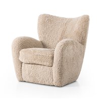 The Amelie Chair features soft beige faux-shearling upholstery, wide armrests, and a deep seat. With overall dimensions of 33.75"w x 38.50"d x 36.50"h, it’s ideal for relaxing comfort against a plain white background.