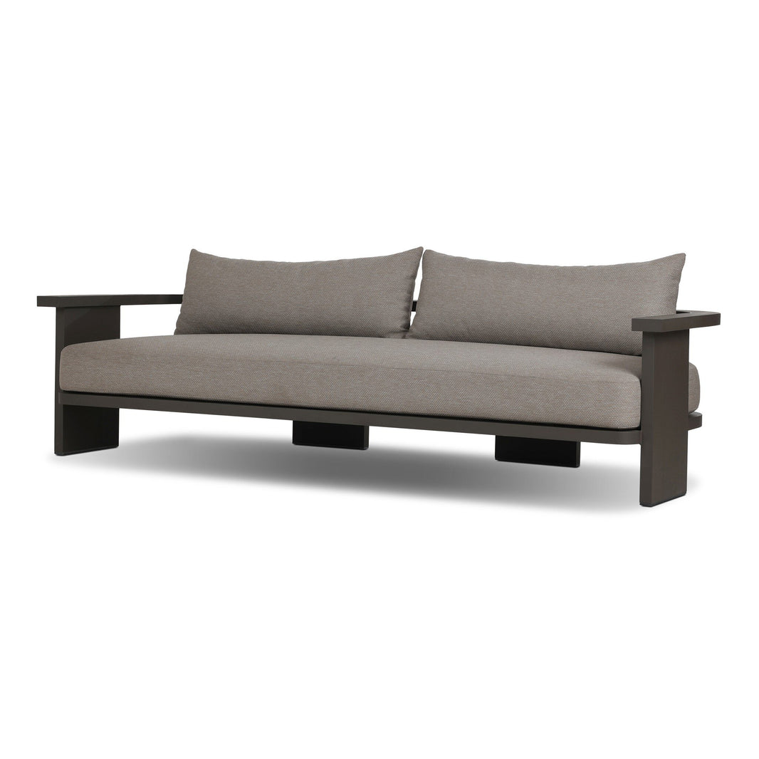 The Aluminum Wide-Frame Outdoor Sofa has a minimalist design with a sturdy aluminum frame, wide armrests, and light gray Italian upholstery. Its clean, low profile and high-performance fabric cushions provide comfort and lasting style.