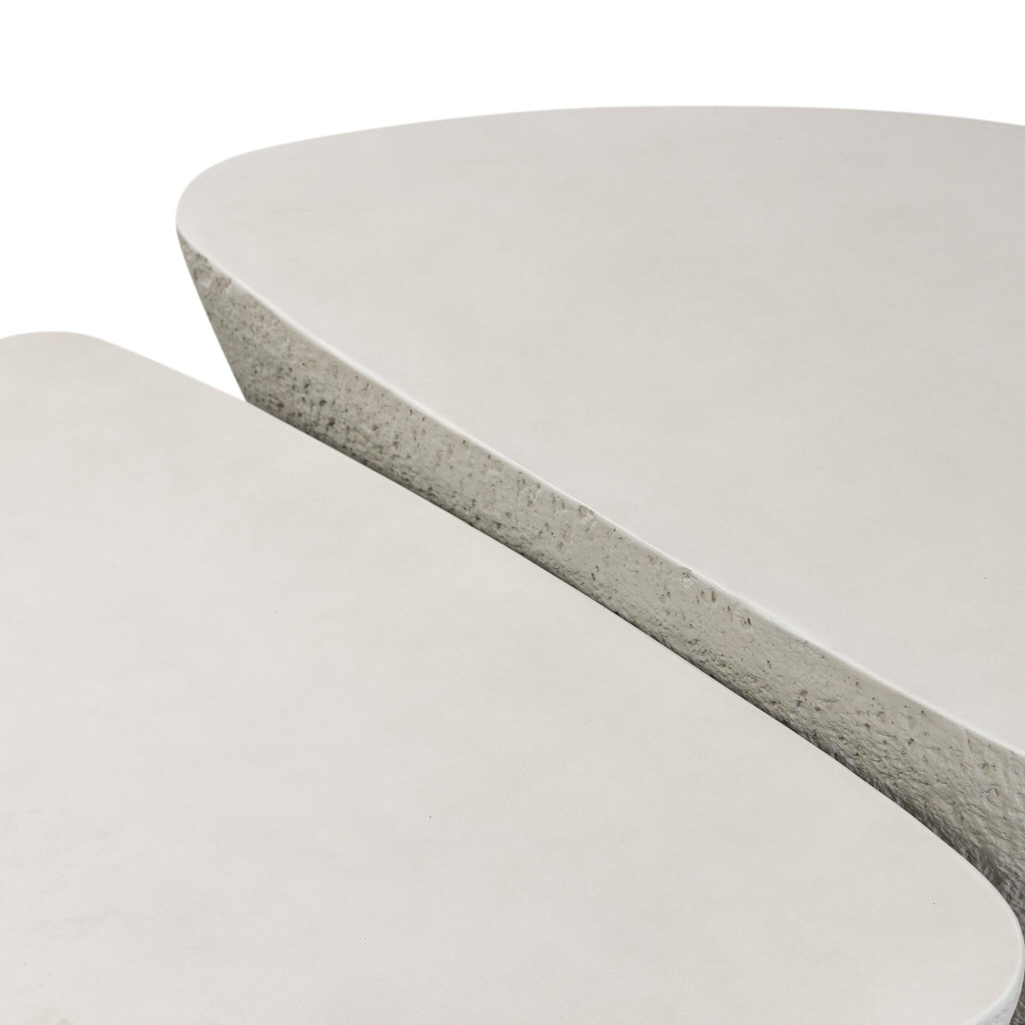 Close-up of two overlapping Concrete Organic Nesting Outdoor Coffee Tables with smooth, off-white surfaces, rounded edges, and a textured side, set against a plain white background.
