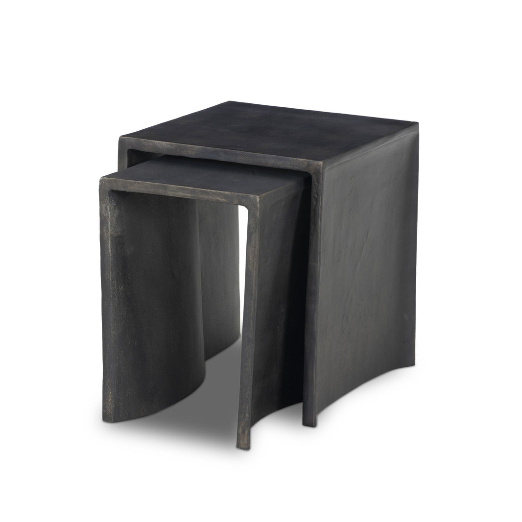 The Aluminum Curved Legs | Outdoor Nesting End Tables feature two modern, black cast aluminum tables with smooth surfaces and unique curved legs. The smaller table can be partially nested under the larger for a sculptural, minimalist look.