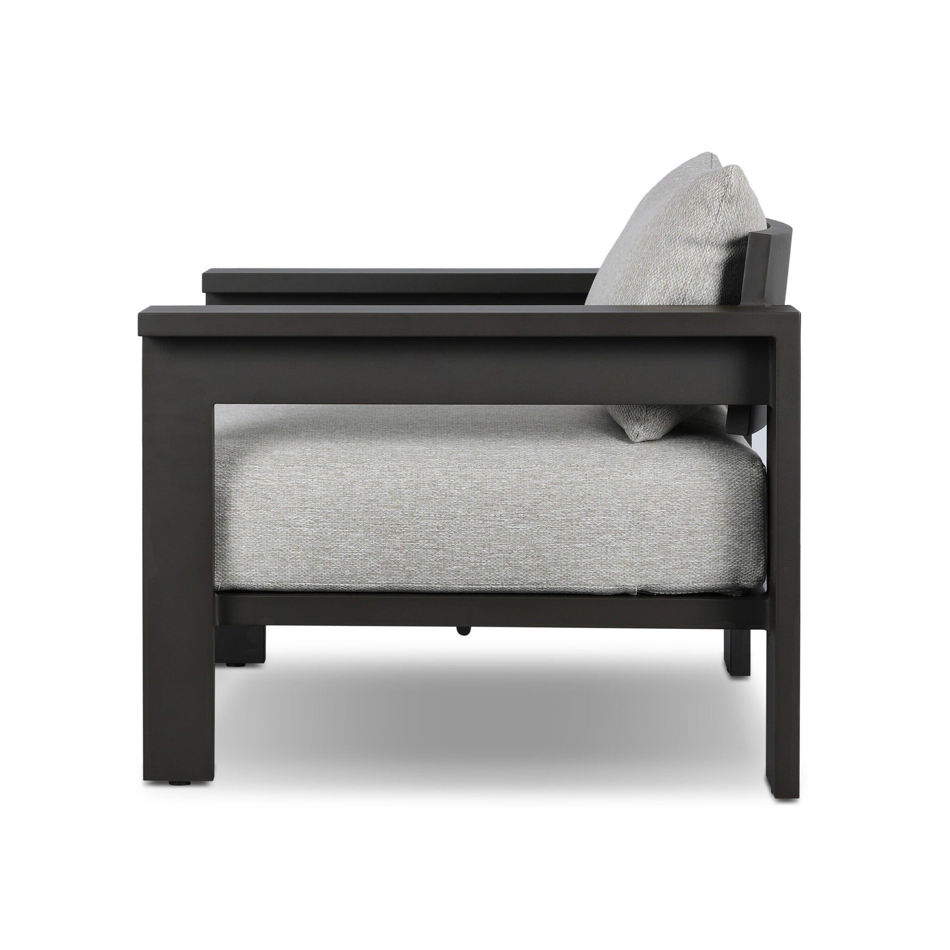 Side view of the Aluminum Angular Accent Outdoor Chair by Canyon Creative Studio, featuring a matte black aluminum frame and light gray cushions, shown against a white background; overall dimensions available upon request.