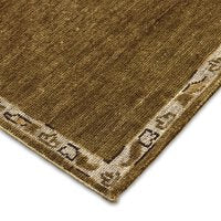 Corner of the Astana Hand-Knotted Rug in brown with a beige and brown patterned border featuring simple geometric designs. Overall size: 10' x 14'.