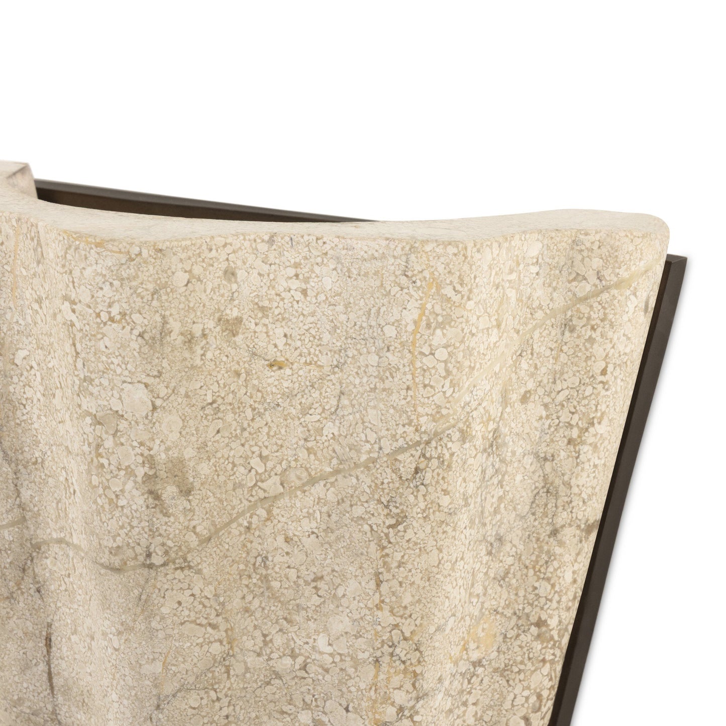 Close-up of the Astra Sconce’s textured beige, stone-like surface with a wavy edge and natural patterns, set against a white background. Measures 8.50w x 4.50d x 7.75h, with a dark angular detail partially visible behind it.