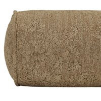 A close-up of the April Bolster Pillow—a cylindrical, textured, light brown cushion—rests on a modern storage shelf, highlighting its fabric detail and rounded end.
