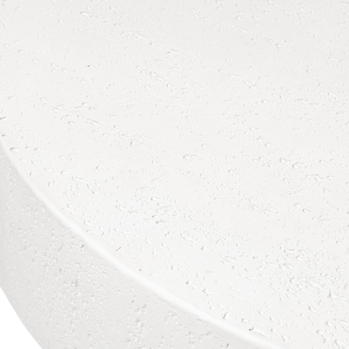 A close-up of the Solid Concrete Plinth-Style Outdoor Coffee Table highlights its white, textured, rounded surface with small pits and subtle unevenness in the material.