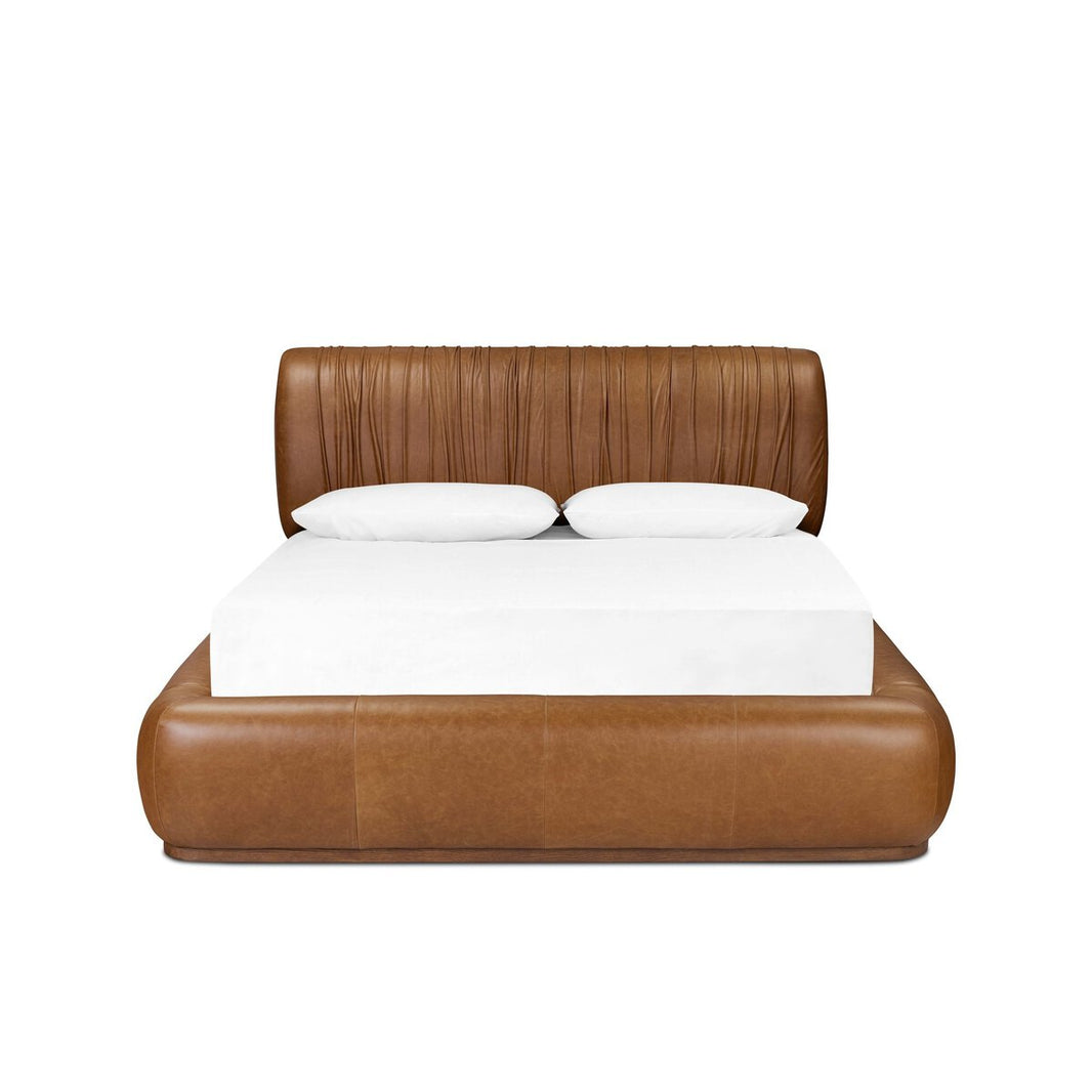 The Ronaldo Bed features a brown leather upholstered frame and headboard with vertical stitching, a white mattress, and two white pillows. Dimensions are 91.25"w x 101"d x 41"h, shown against a plain white background.