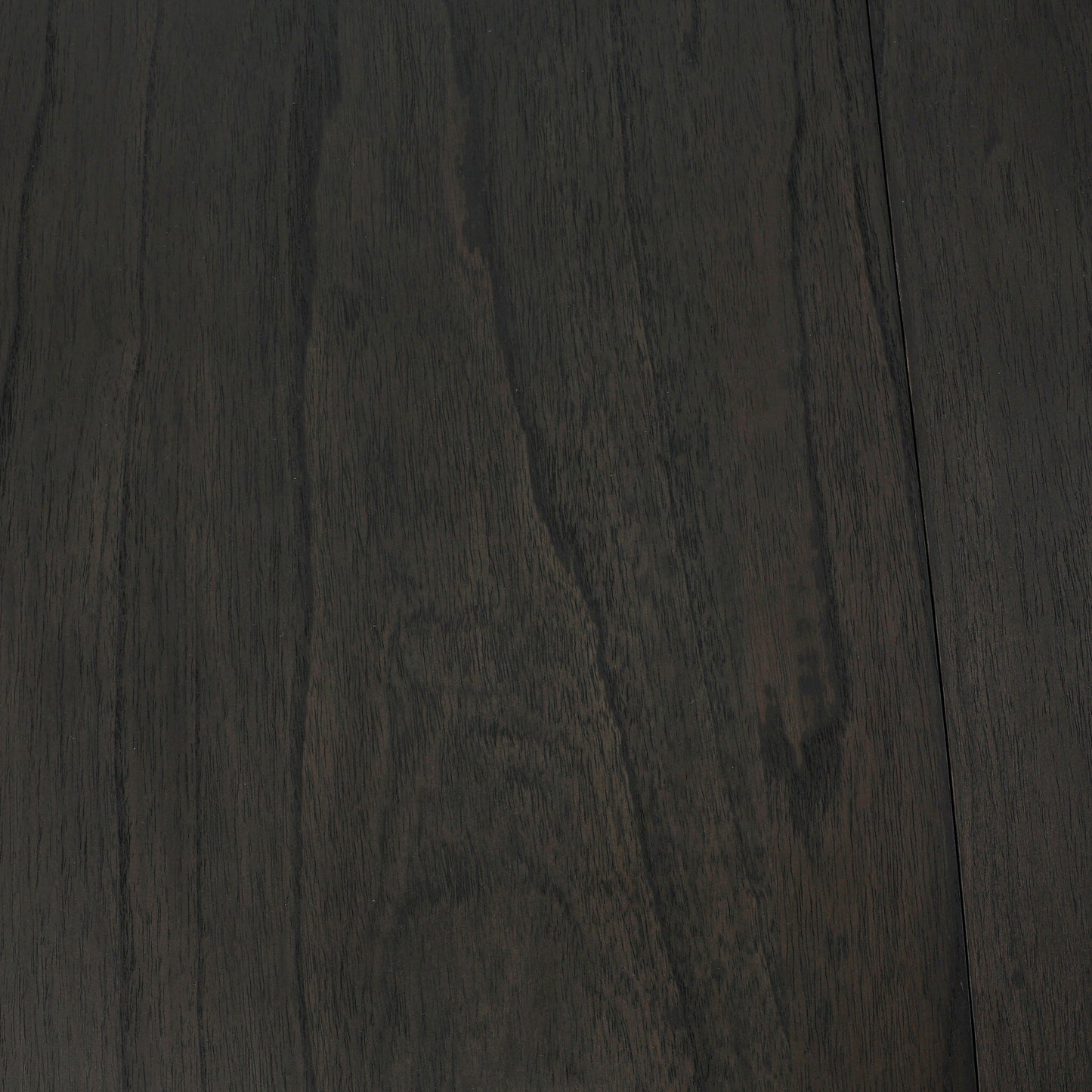 Close-up of the Pemble Extension Dining Table’s dark brown wood surface, featuring visible natural grain patterns and a smooth, polished finish—ideal as a 48x48 square dining table or bold centerpiece.