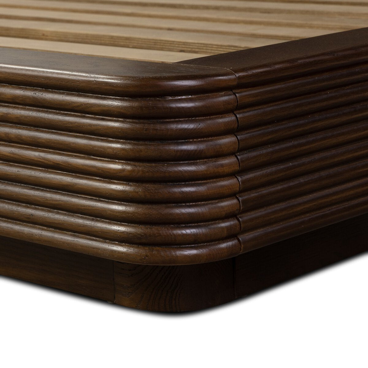 Close-up of the Benny Bed’s corner, featuring rounded edges and horizontal grooves with a smooth, polished dark brown finish that highlights careful attention to overall dimensions.