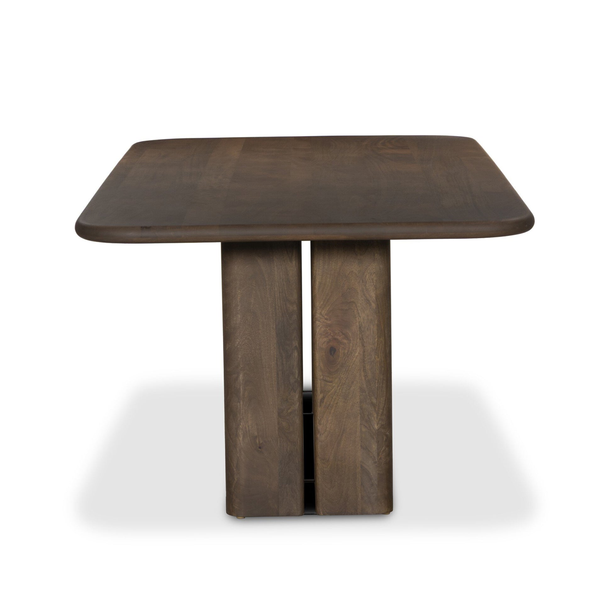 The Rishi Dining Table features a modern wooden design with a square top and rounded edges, supported by two wide vertical panels—perfect as stylish office furniture, shown against a plain white background.