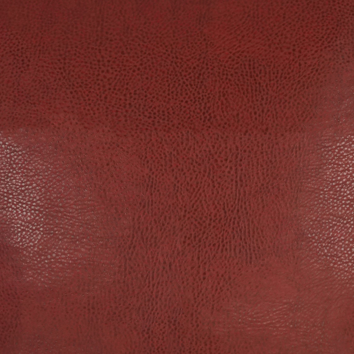 Close-up of the Wrangler Pillows’ textured, reddish-brown leather surface featuring a subtle sheen and natural grain patterns throughout, enhanced by a durable polyurethane finish.