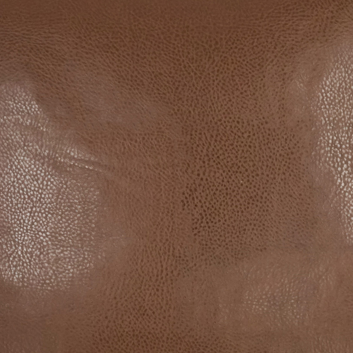 Close-up of the textured brown leather surface of Wrangler Pillows, showcasing visible grain patterns and subtle light reflections, expertly crafted to complement polyurethane or polyester materials for added durability and style.