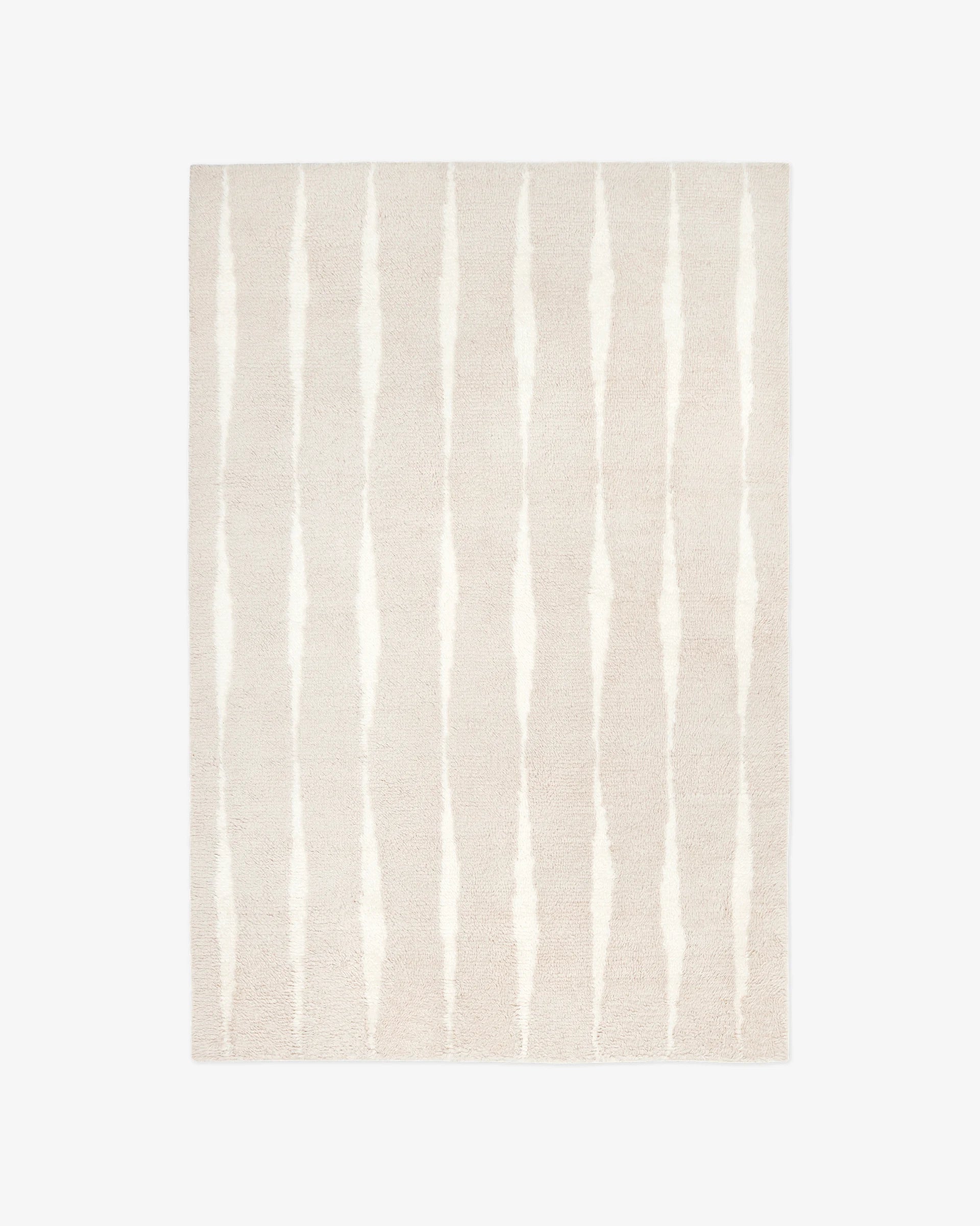 The Shag Pale/Sand Rug features a light beige background with evenly spaced, vertical irregular white stripes.
