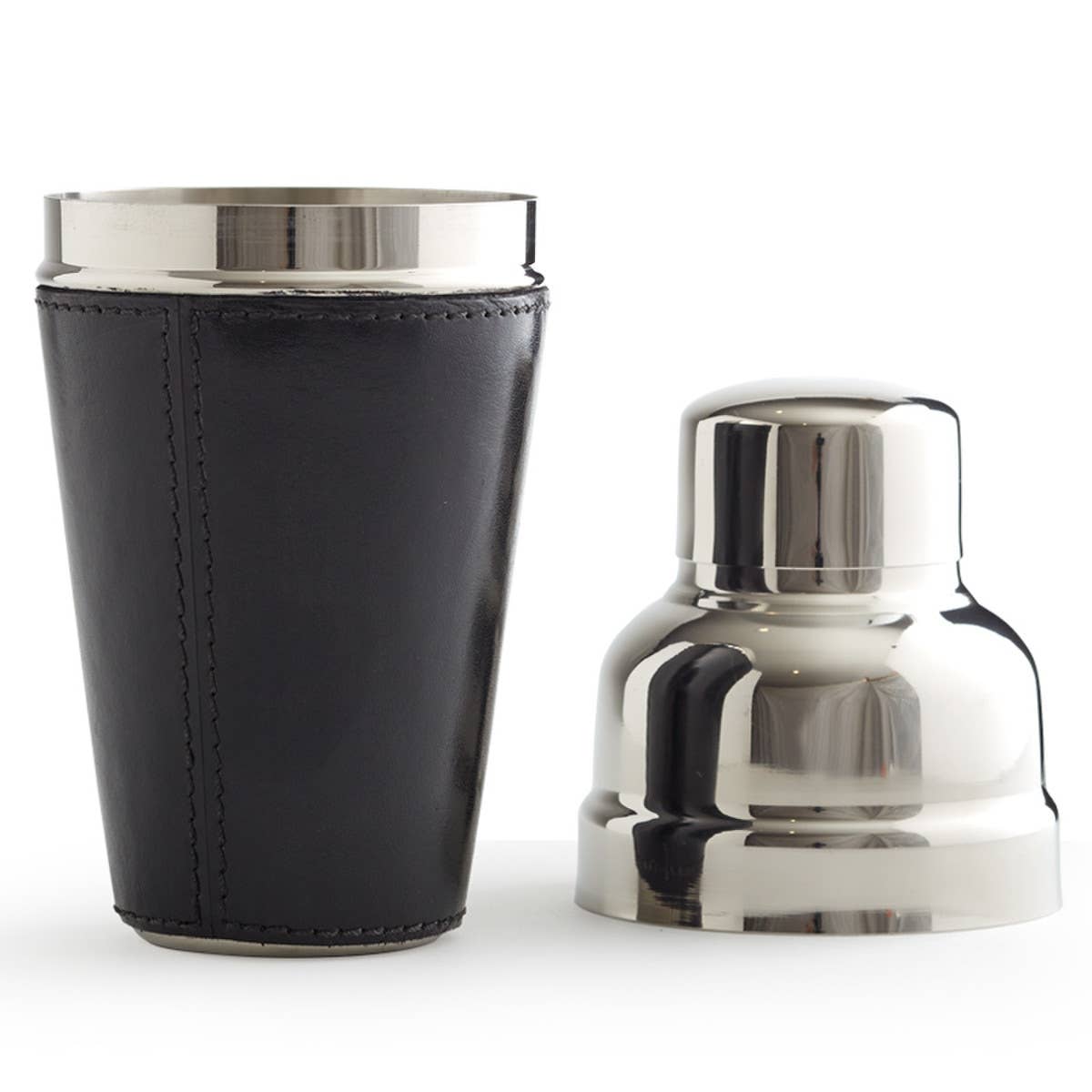 The Leather Cocktail Shaker Black features a stainless steel body with a sleek black leather sleeve and matching lid, elegantly displayed on a white background—an ideal bar gift.