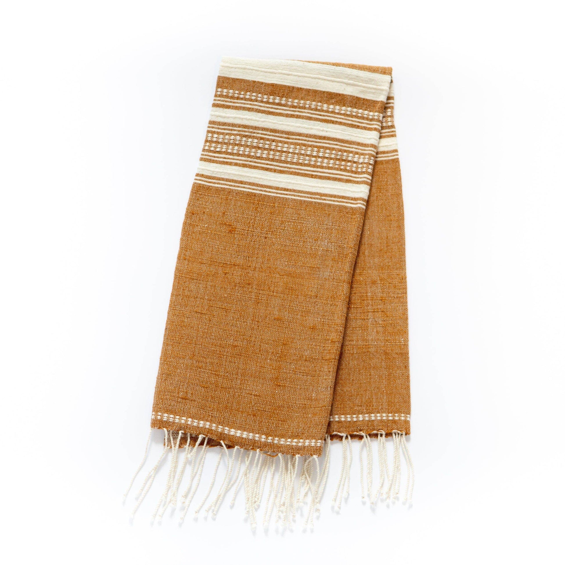 A Handwoven Ethiopian Cotton Hand Towel, brown with white horizontal stripes near one end and white fringes at both ends, is displayed folded on a white background.