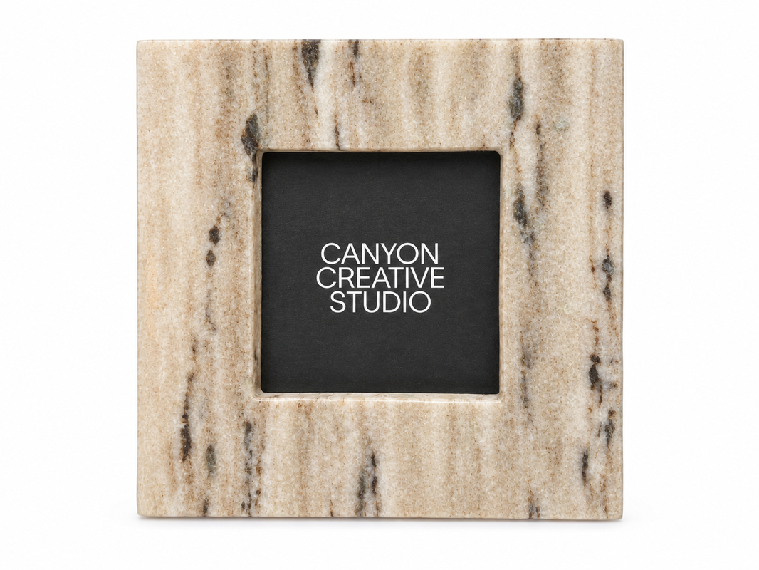 A square marble Square Stone Standing Picture Frame with beige and brown streaks, styled like a 6-inch tile, features a placeholder reading CANYON CREATIVE STUDIO in white on a black background.