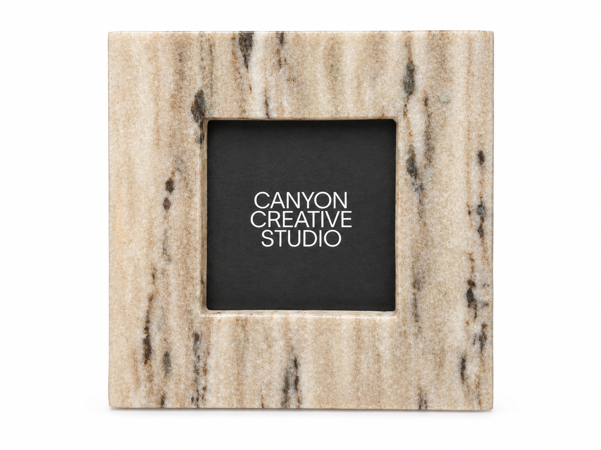 A square marble Square Stone Standing Picture Frame with beige and brown streaks, styled like a 6-inch tile, features a placeholder reading CANYON CREATIVE STUDIO in white on a black background.
