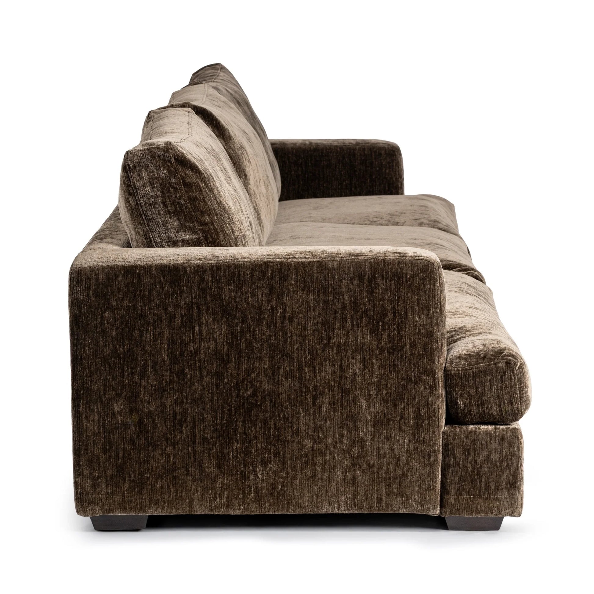 Side view of the Mossed Brown 3pc Sofa—a plush, brown velvet sectional with two back cushions, square arms, and short dark legs—isolated on a white background; a stylish piece of living room furniture.