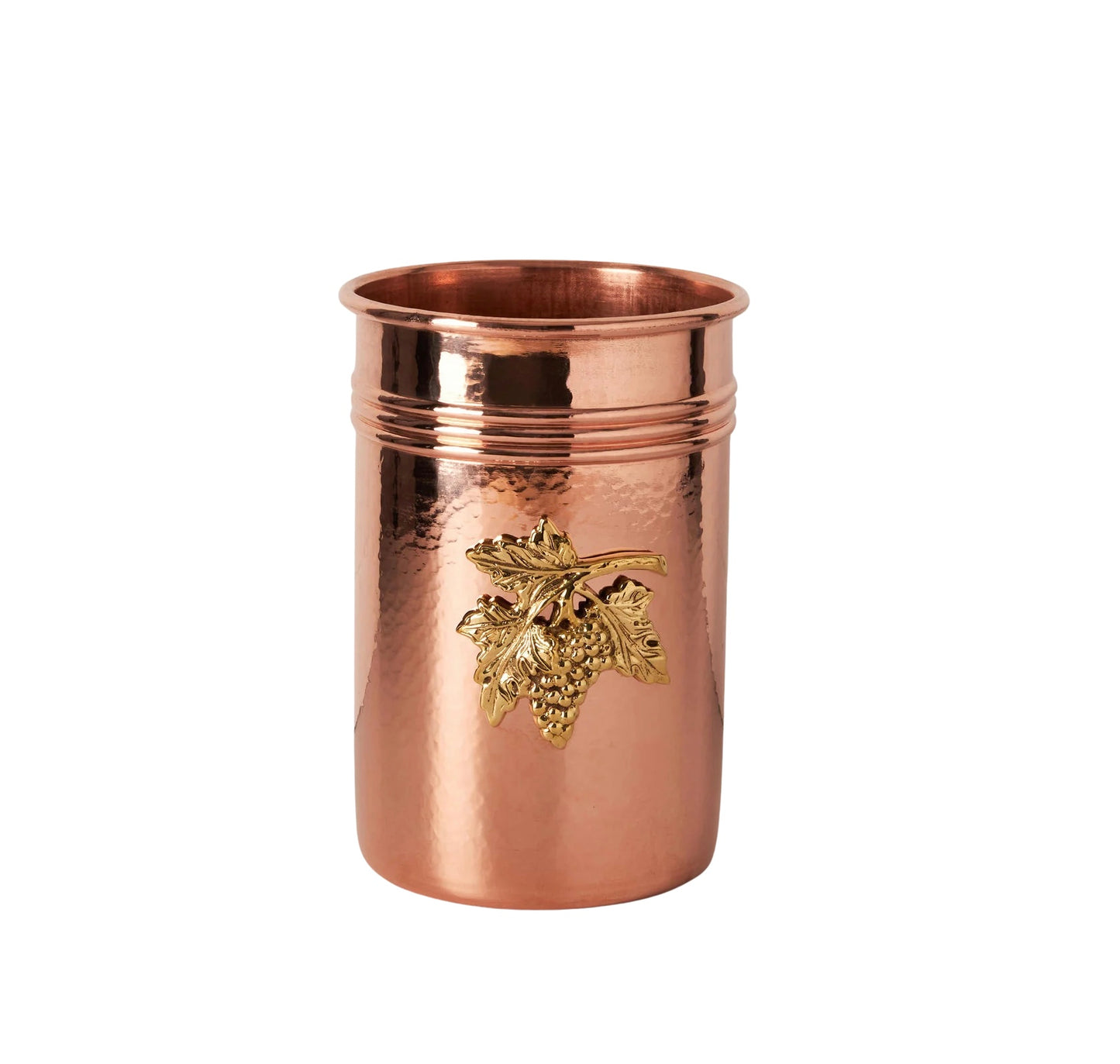 The Copper Utensil Holder features a hammered copper body with a raised, gold grapevine motif on the front, a shiny finish, and two decorative rings near the rim.