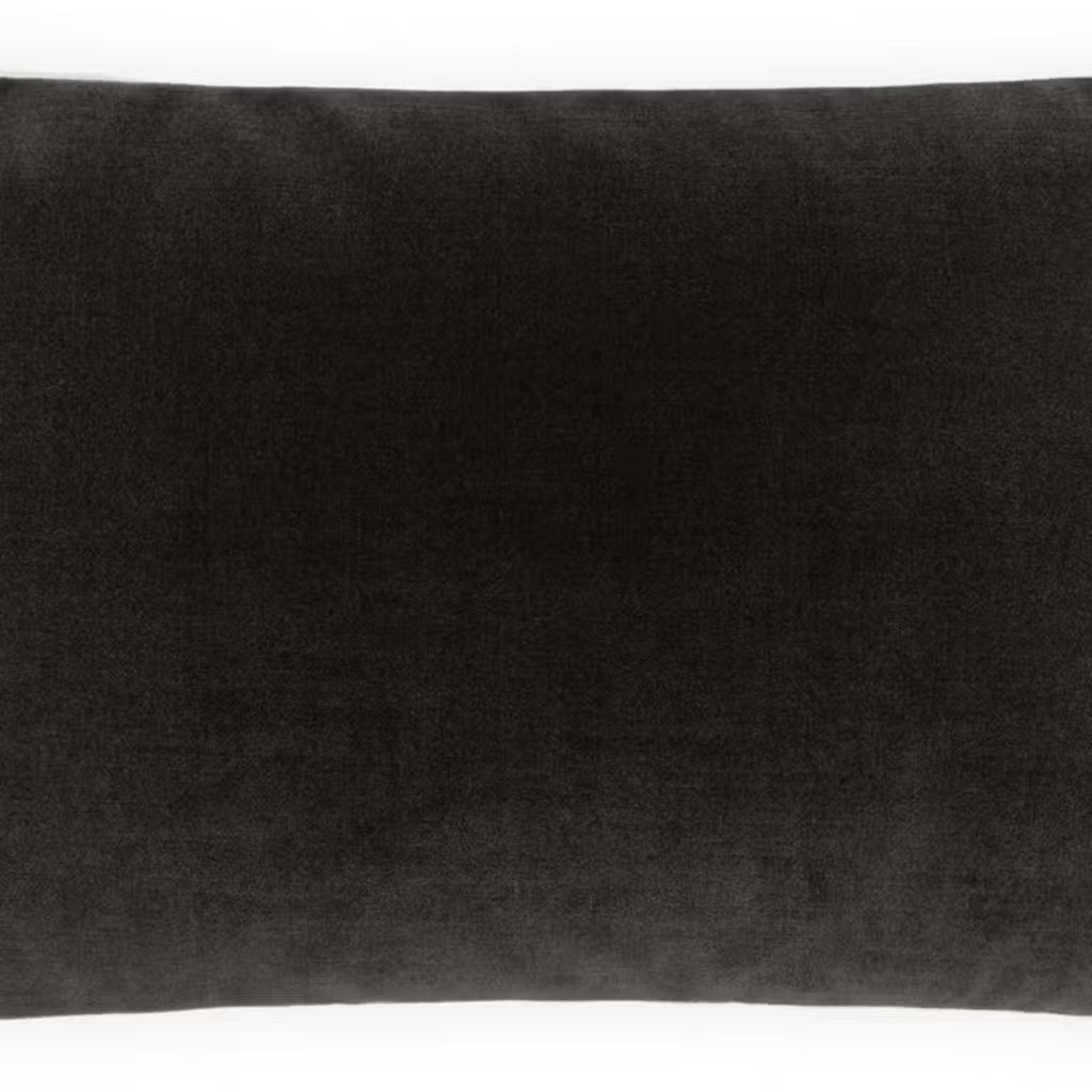 The Shadow Lumbar Pillow, a rectangular pillow in dark gray measuring 12x22 inches, is displayed against a plain white background. It features a soft, velvety texture and includes a plush polyester insert for added comfort.