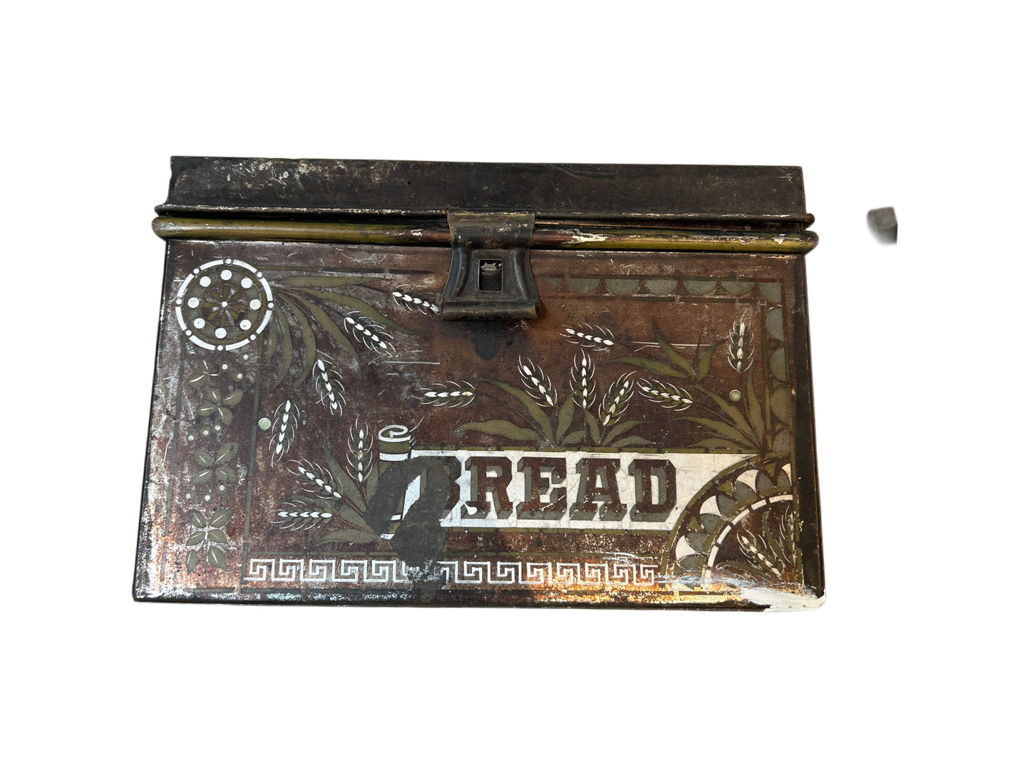 The Bread Box is a vintage metal container with a hinged lid, bold "BREAD" lettering, floral and wheat designs, a front lock, and includes a small detached metal piece.