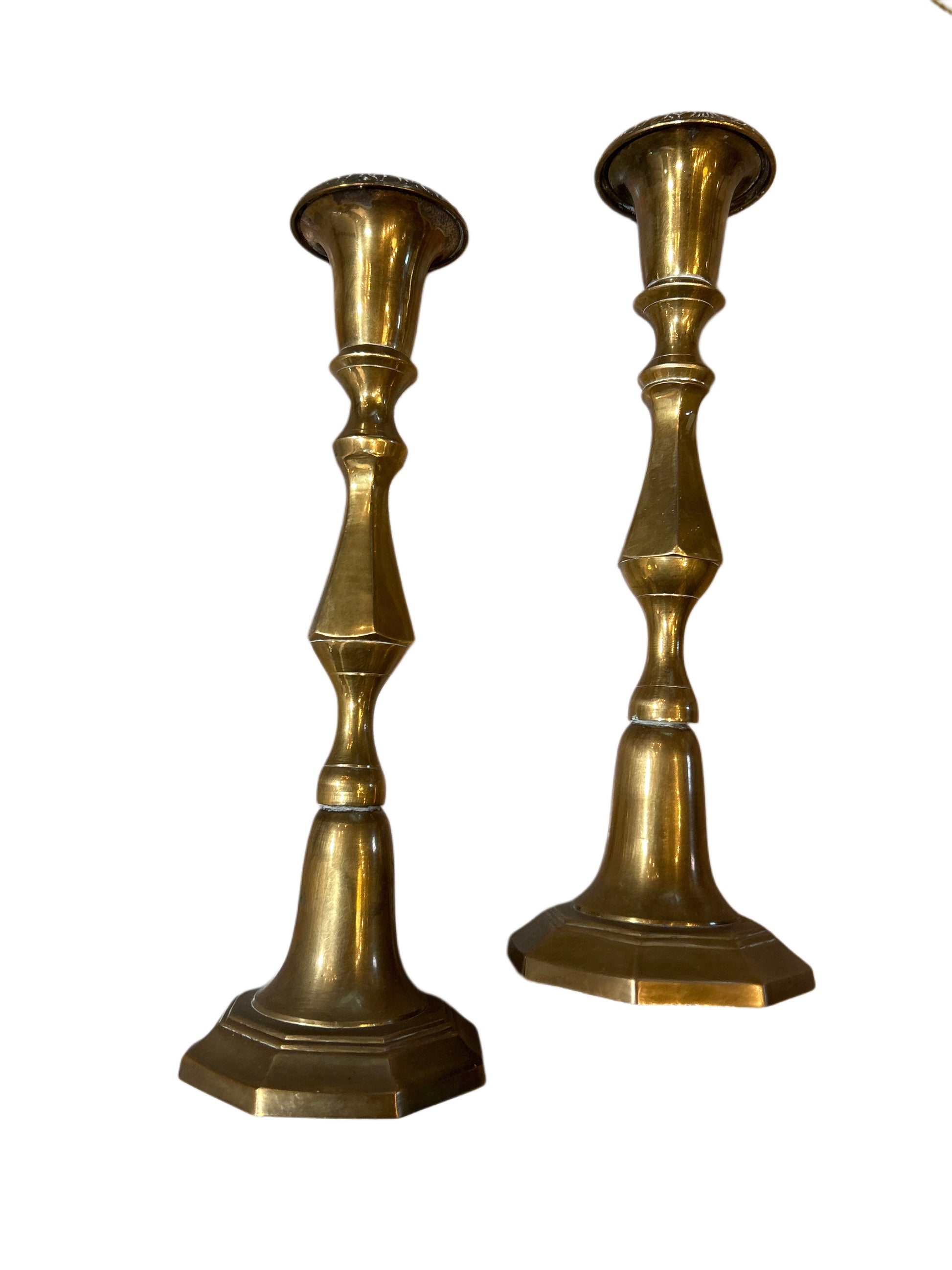 Pair of Brass Candlesticks with vintage geometric, tapered designs and wide hexagonal bases, standing upright against a white background.