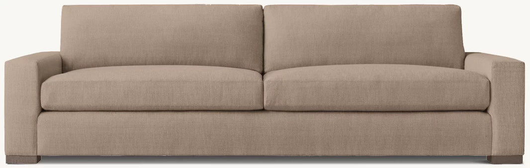 The Latte 2 Cushion Sofa, a beige three-seater with square arms and two large seat cushions in plain fabric, is shown against a light background—ideal to pair with an outdoor storage box for added convenience and style.