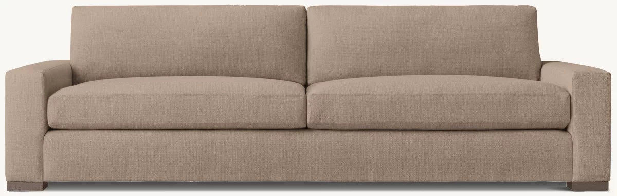 The Latte 2 Cushion Sofa, a beige three-seater with square arms and two large seat cushions in plain fabric, is shown against a light background—ideal to pair with an outdoor storage box for added convenience and style.