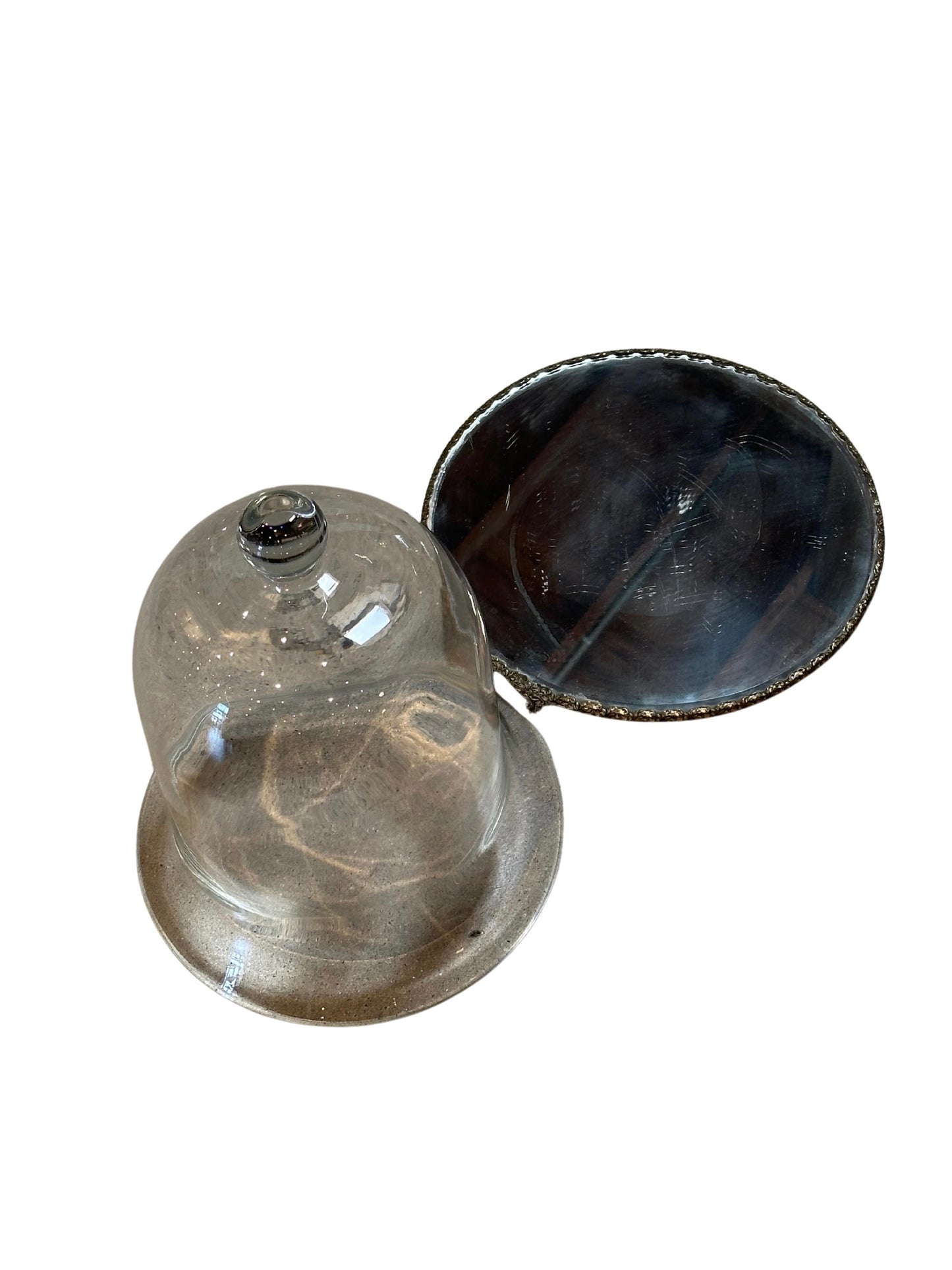 The Tall Glass Cloche with Mirrored Tray is shown partially lifted off its round, dark mirrored base, elegantly presented against a white background.