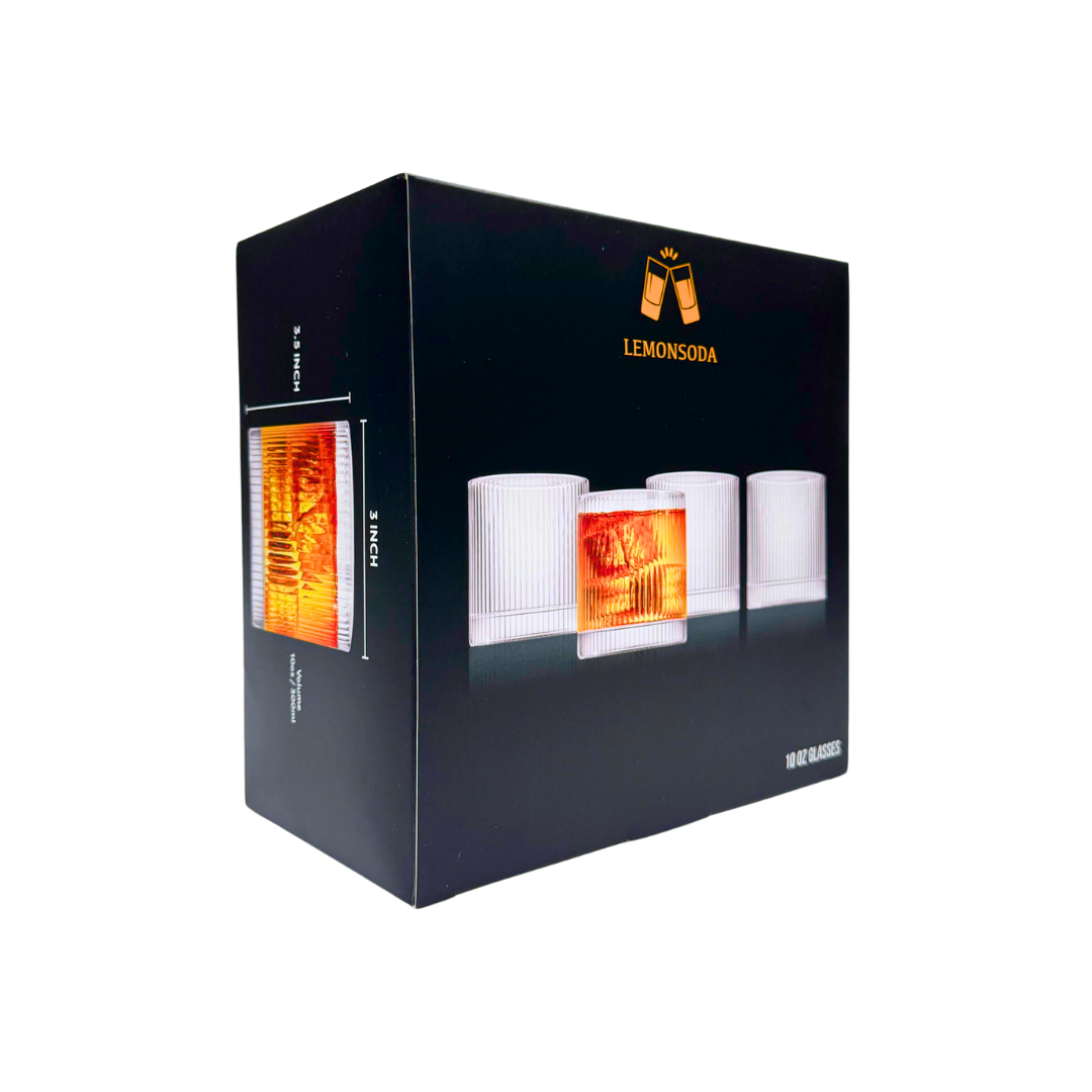 A black box labeled LEMONSODA displays the Vintage Straight Line Tumbler - 10 oz (1pc), with four crystal tumblers—one filled with an orange drink and others empty. Packaging shows images of the lead-free glass on the side.